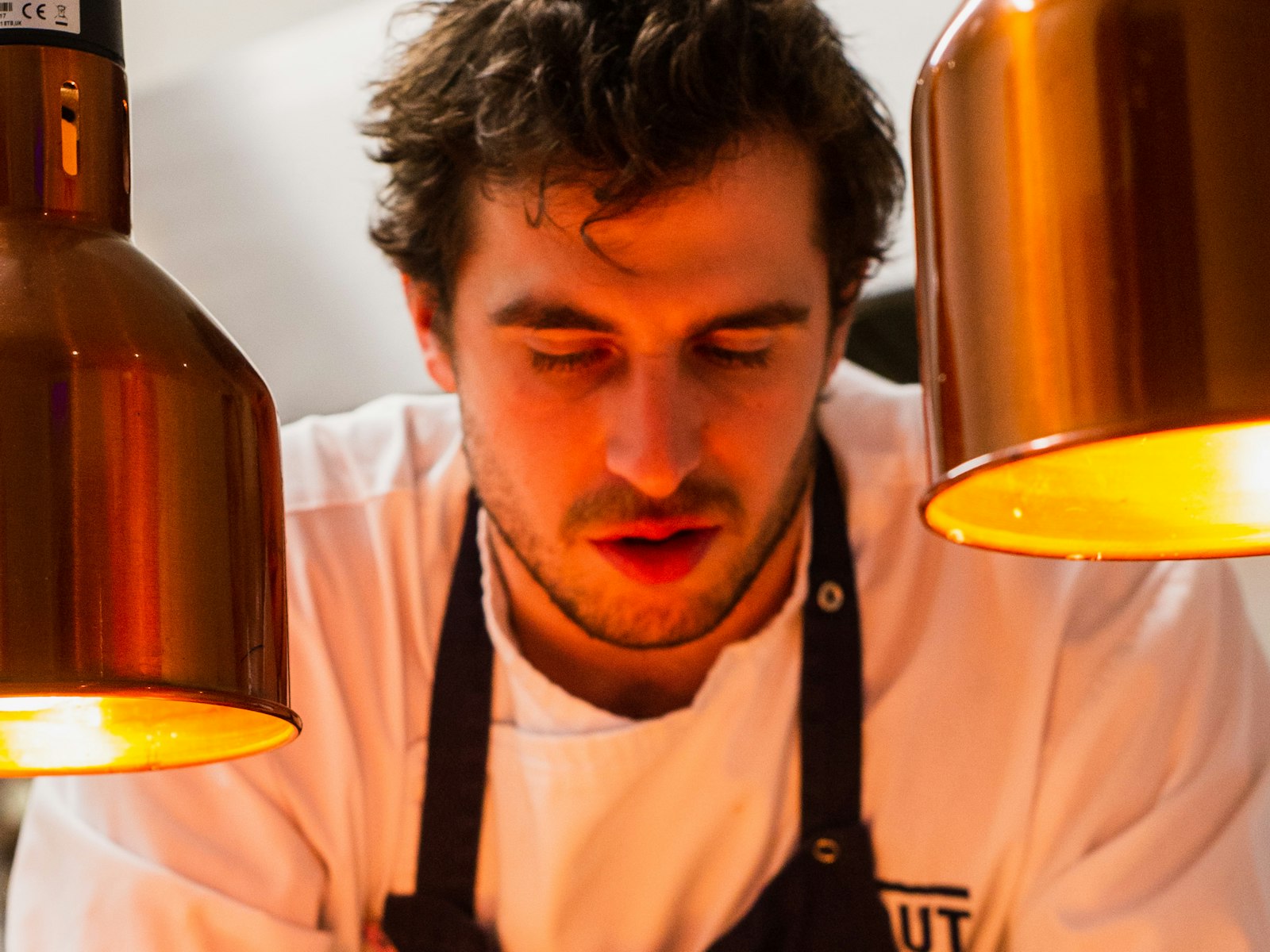 Chef Tudor Arcan concentrat la pass, între două lămpi de cupru aprinse
